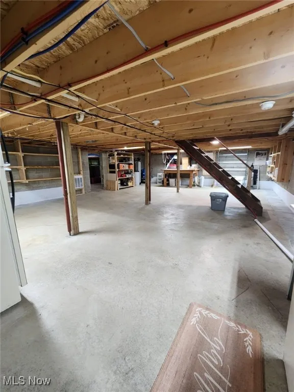 Unfinished basement featuring water heater