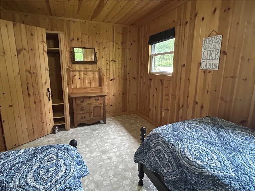 Bedroom with wooden ceiling and wood walls