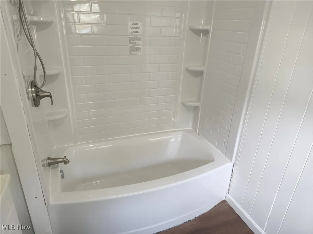 Full bathroom featuring wood finished floors and shower / bath combination