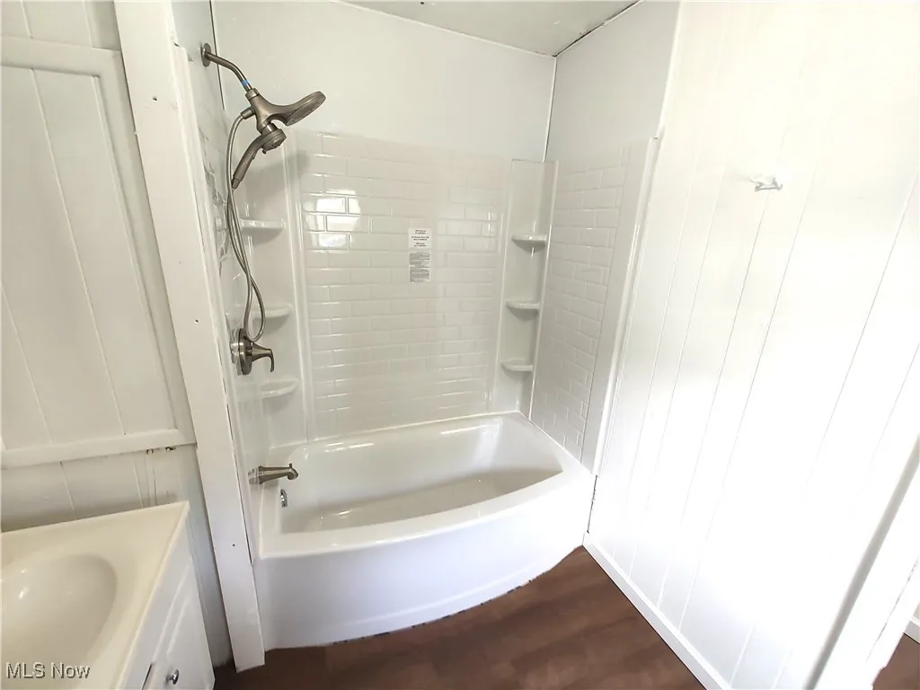 Full bathroom featuring wood finished floors, shower / bath combination, and vanity