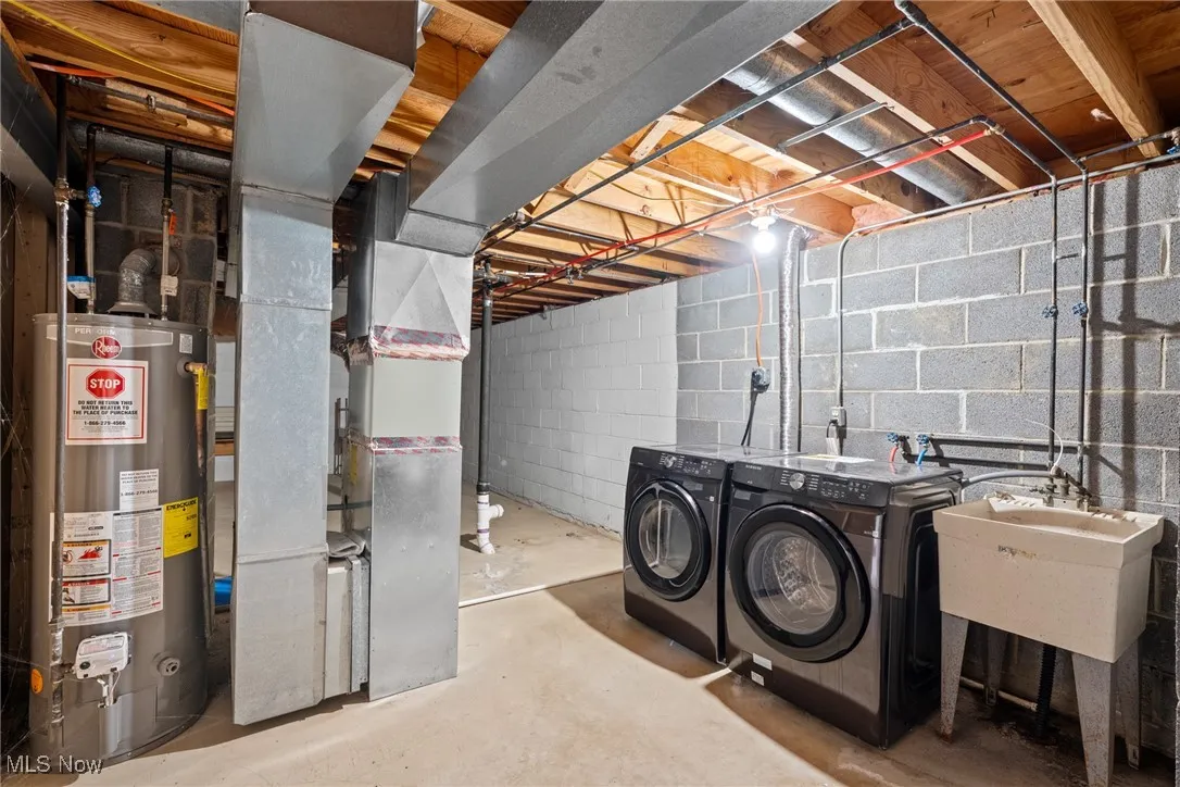 Unfinished basement with water heater, independent washer and dryer, heating unit, and a sink