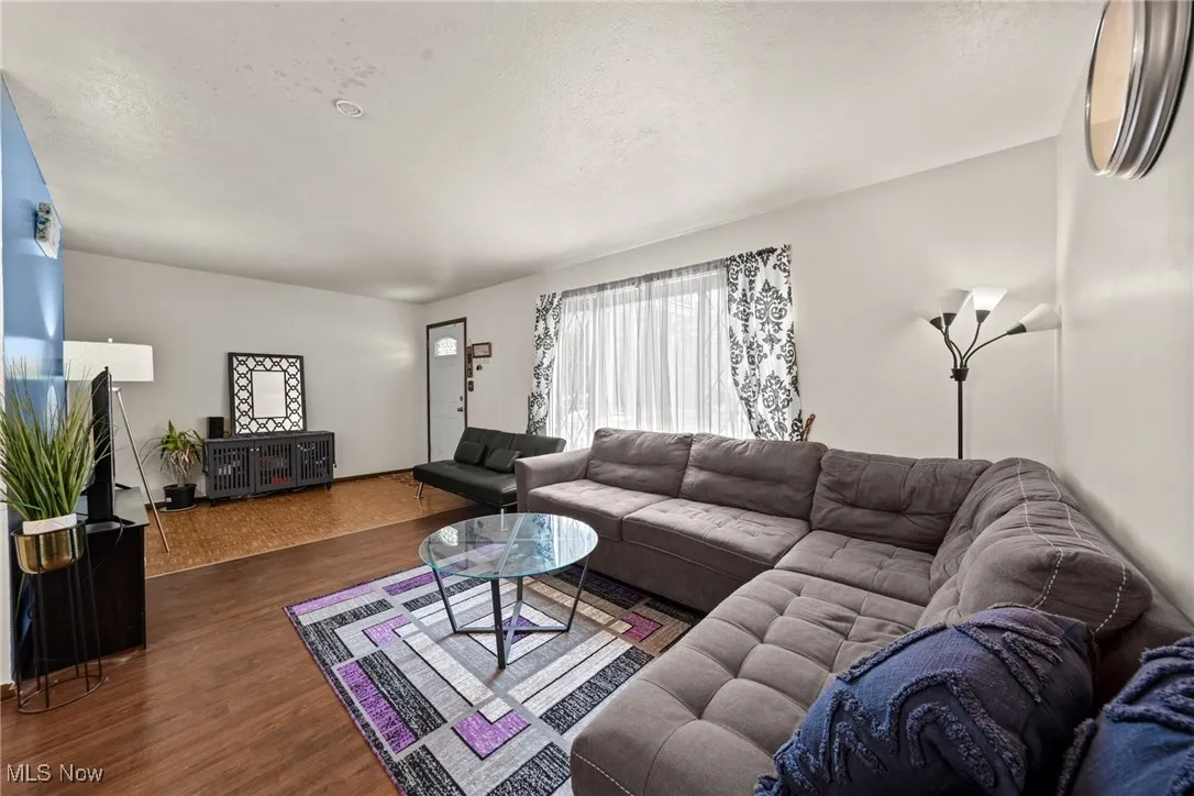 Living room with dark wood-type flooring and a textured ceiling