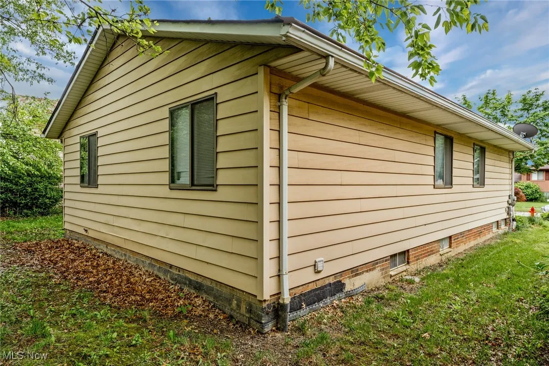 View of property exterior with a lawn