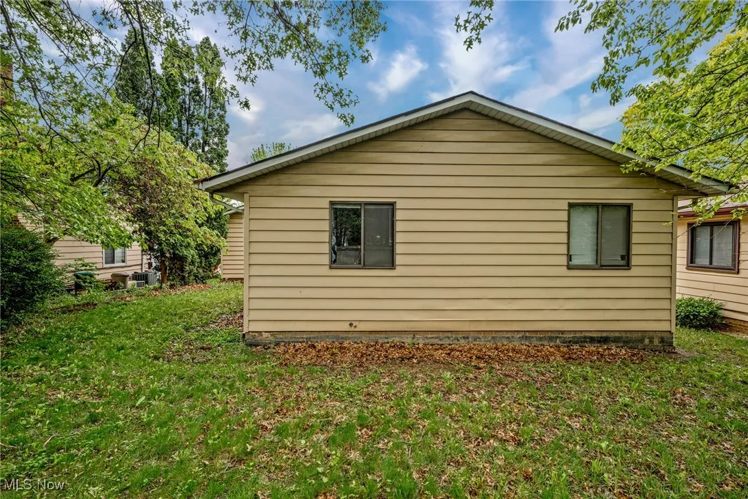 View of property exterior with a lawn