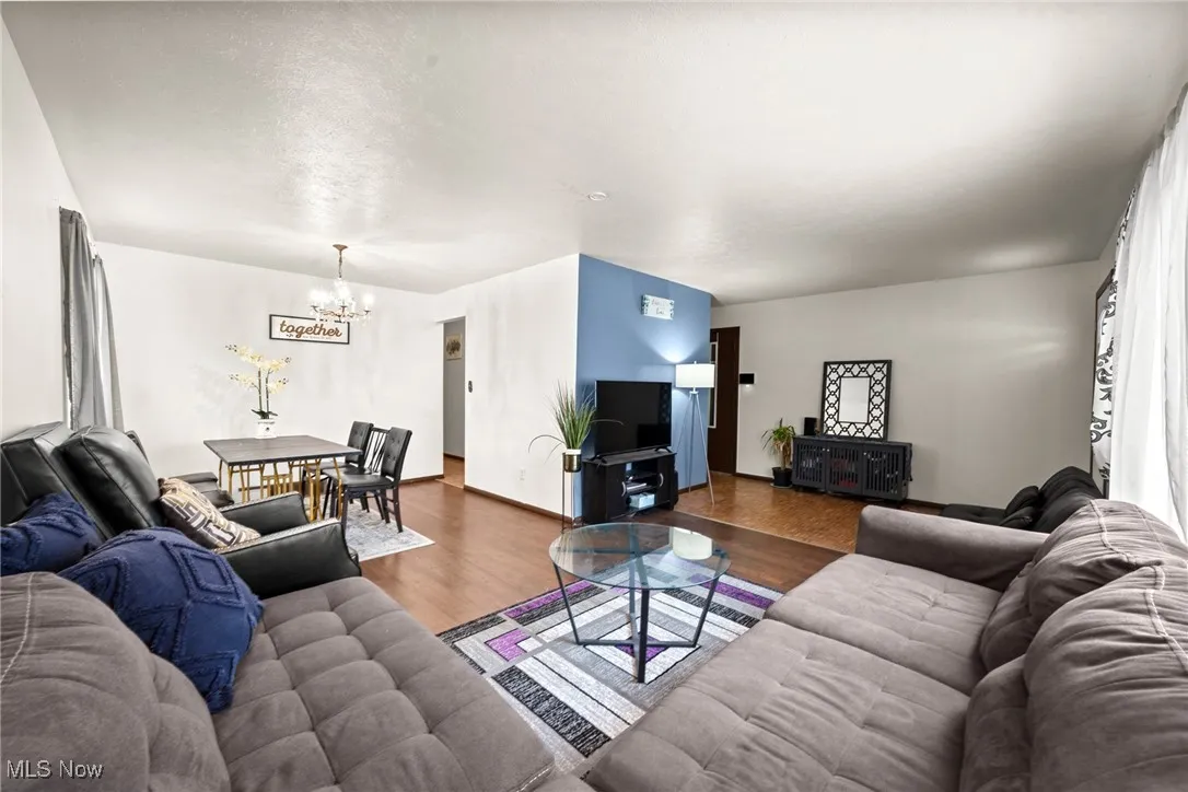 Living room featuring a chandelier, wood finished floors, and baseboards