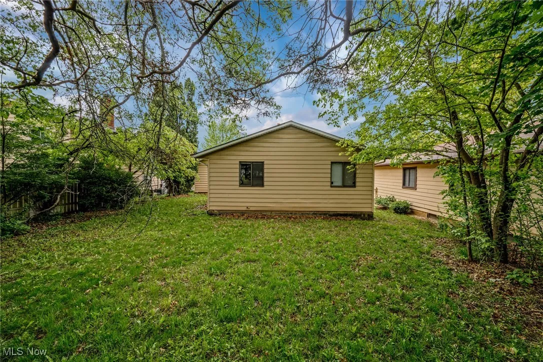 Rear view of house featuring a yard