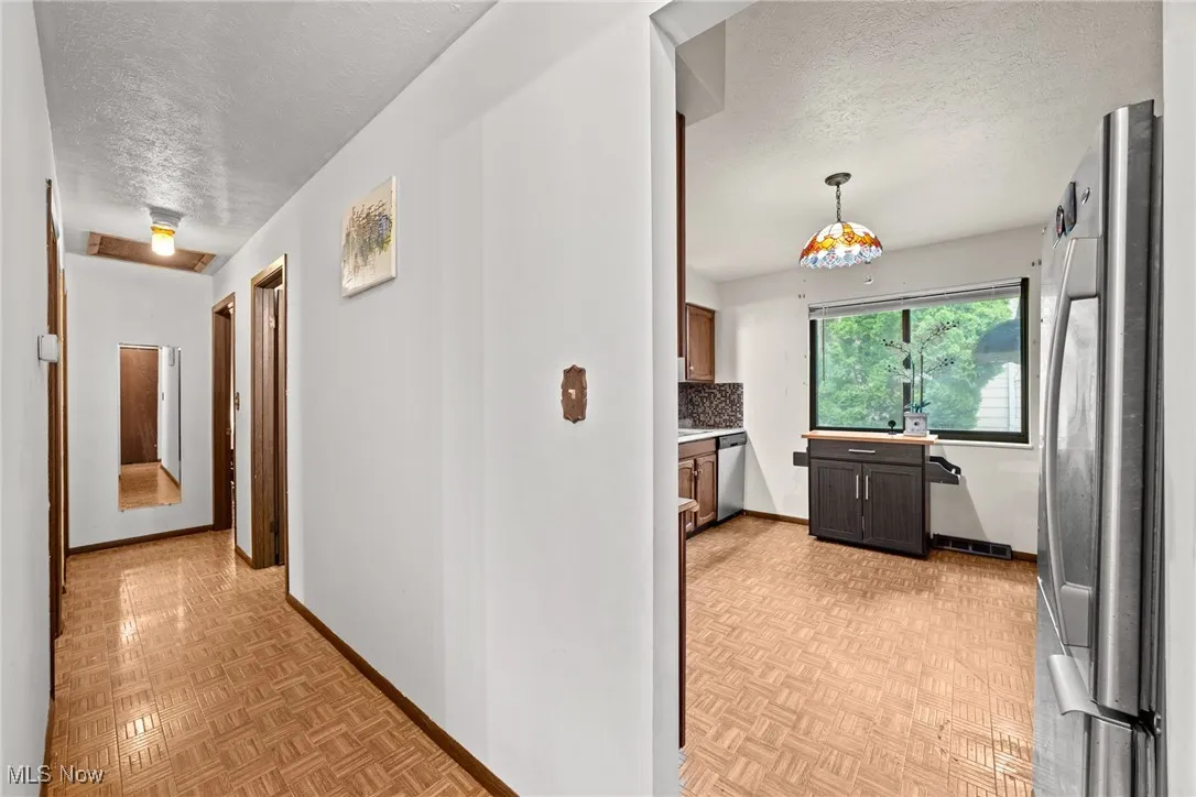 Corridor featuring a textured ceiling and baseboards