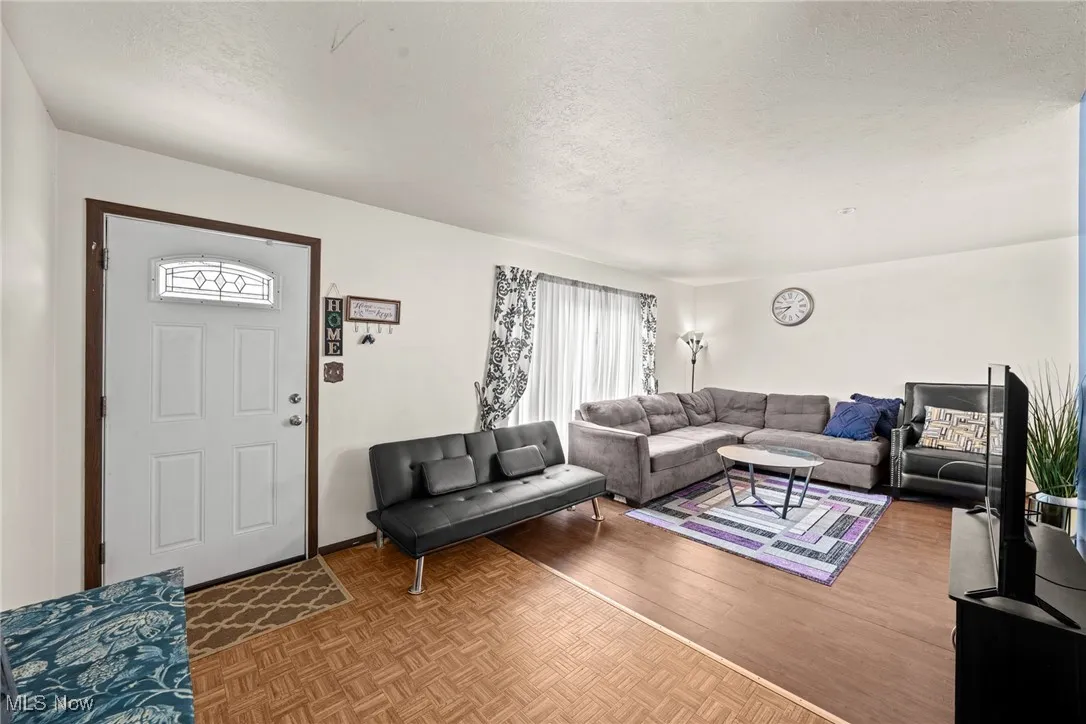 Living area with a textured ceiling and parquet floors