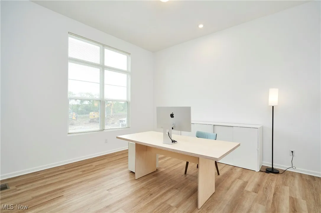 Office area with light wood-type flooring and baseboards