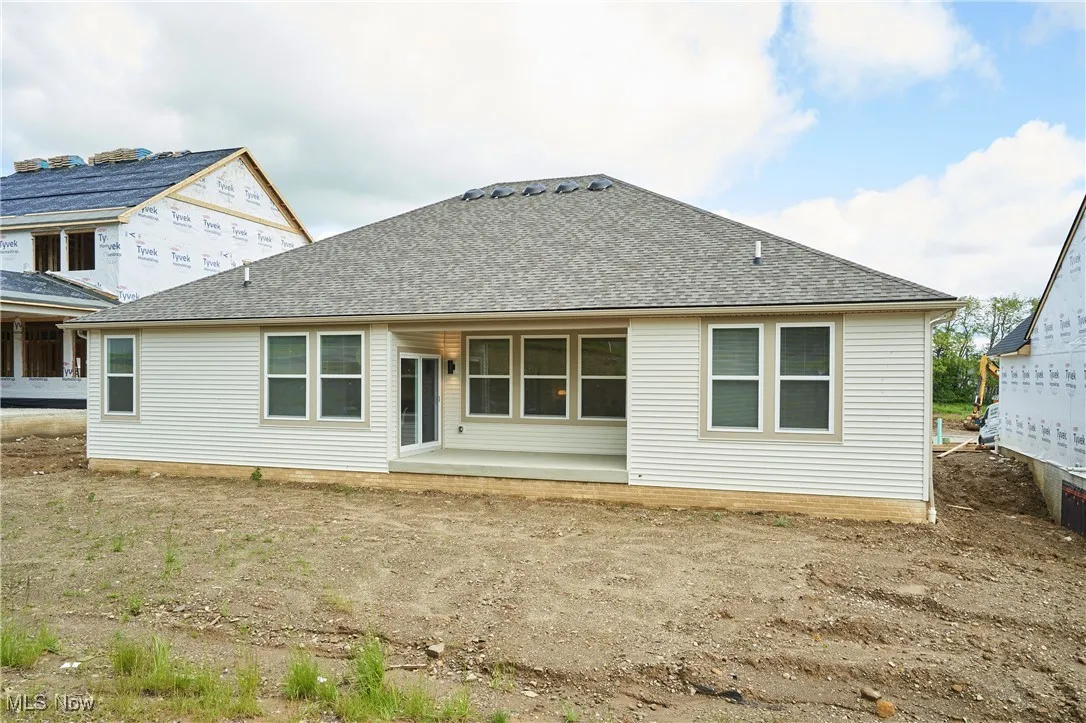 Back of property with a shingled roof
