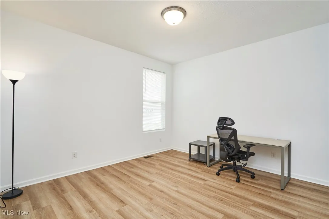 Unfurnished office with light wood-type flooring and baseboards