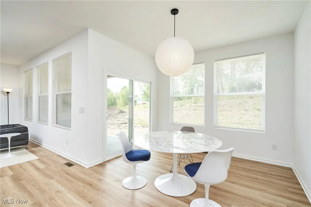 Dining space with light wood-style flooring and baseboards
