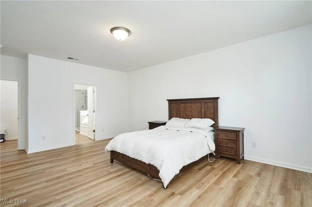 Bedroom with light wood finished floors and baseboards