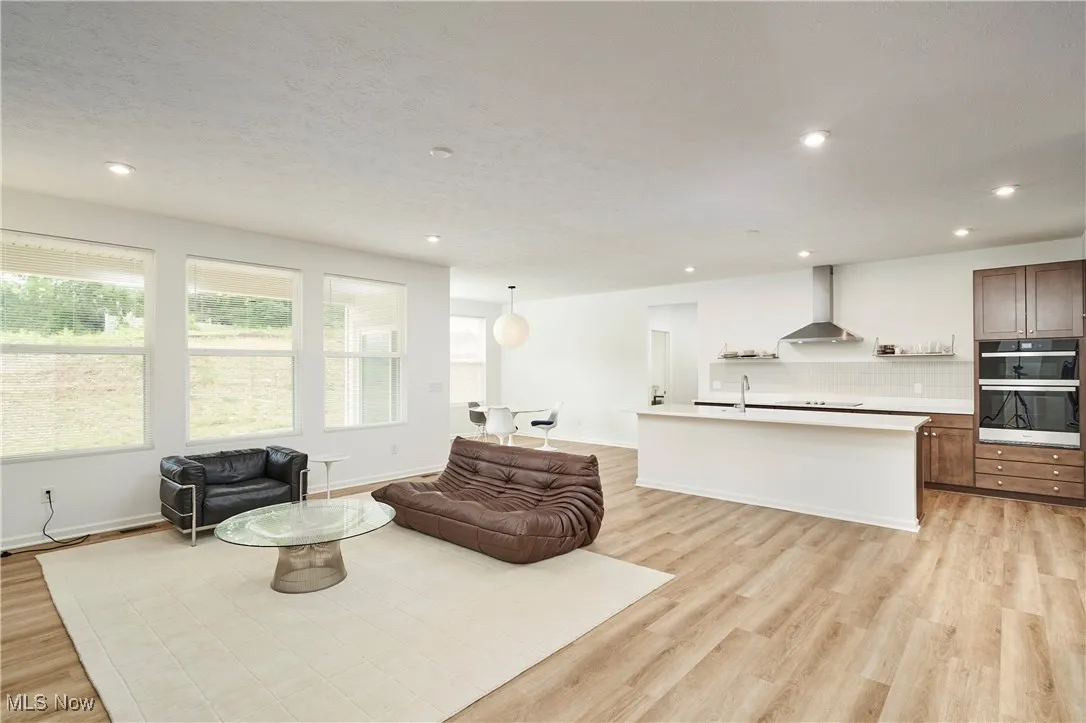 Living area with light wood-style flooring, recessed lighting, and baseboards