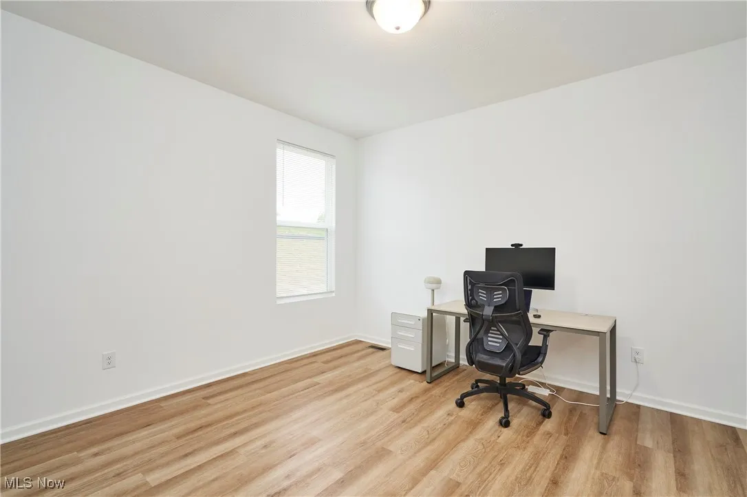Office space featuring light wood-style flooring and baseboards