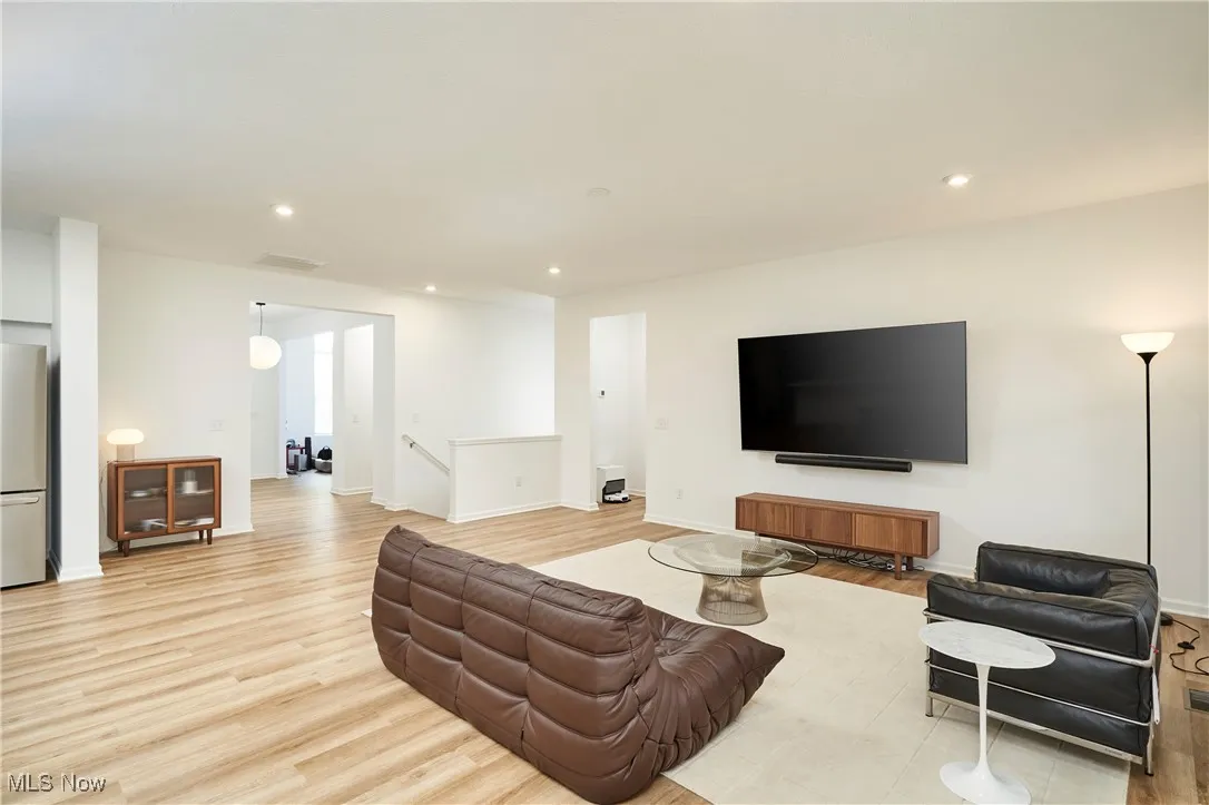 Living area with light wood-type flooring, recessed lighting, and baseboards