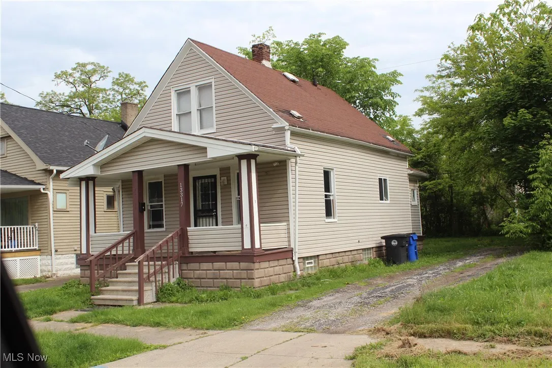 Bungalow-style home featuring covered porch, a chimney, and a shingled roof
