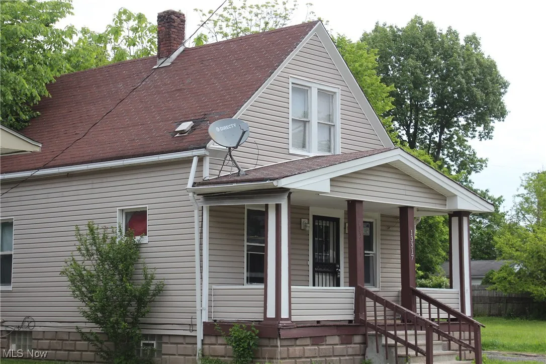 View of front of property with a chimney, crawl space, a shingled roof, and a porch
