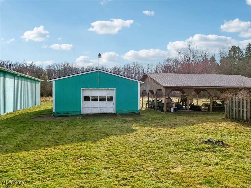 View of outbuilding featuring a lawn and a garage