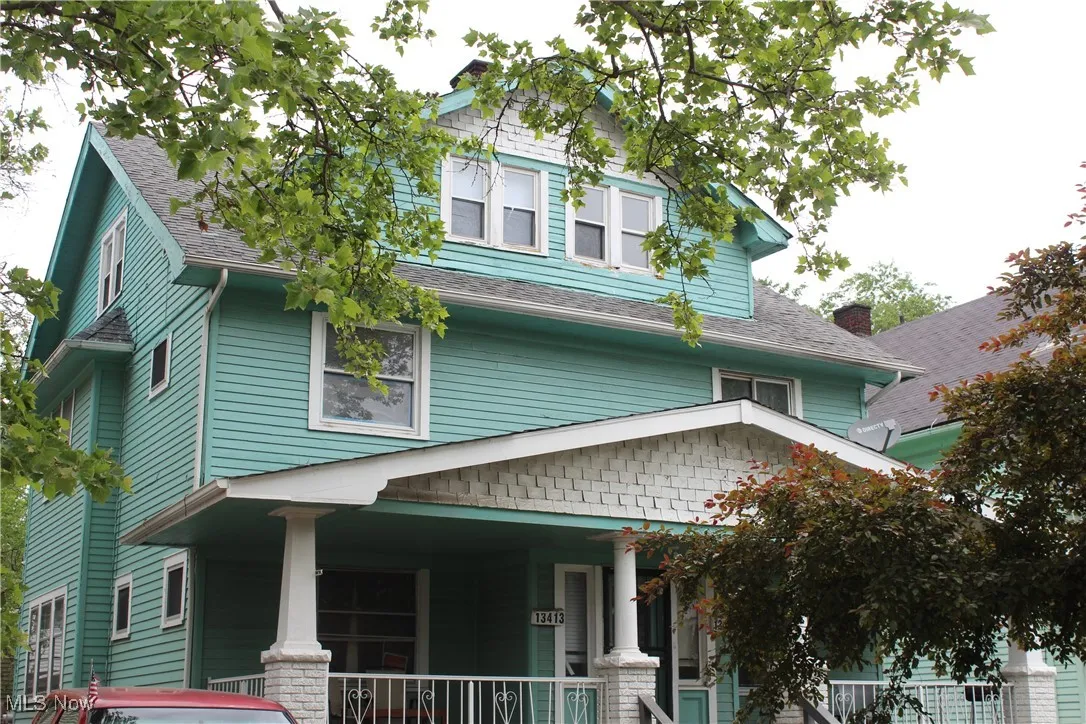 Traditional style home with covered porch and a shingled roof