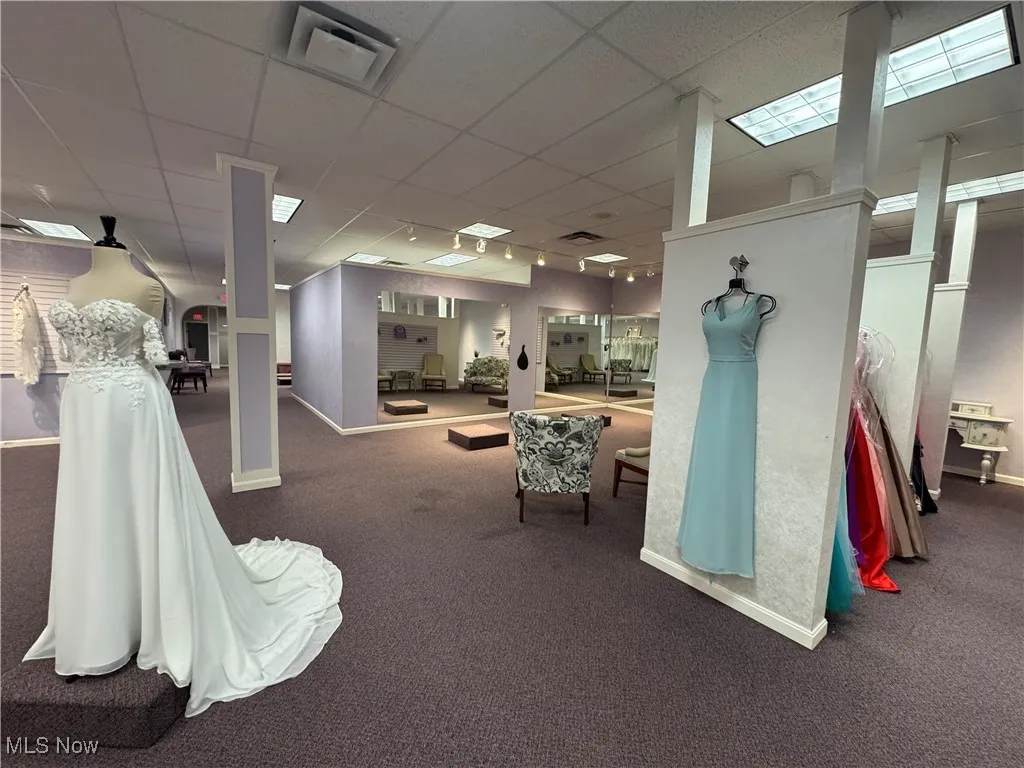 Miscellaneous room featuring carpet floors, baseboards, track lighting, and a paneled ceiling