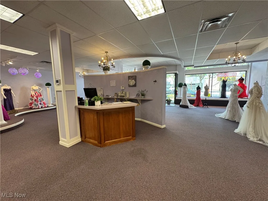 Carpeted  office featuring a chandelier, baseboards, and a paneled ceiling