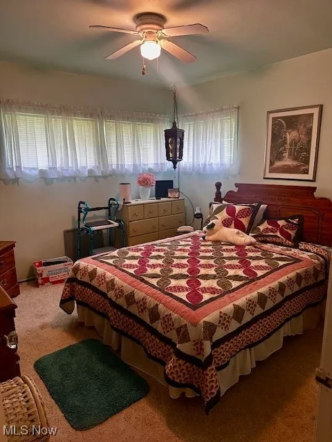 Bedroom featuring ceiling fan and carpet