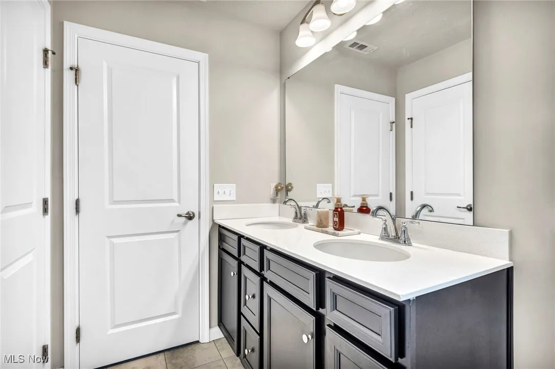 Bathroom featuring double vanity and tile patterned flooring