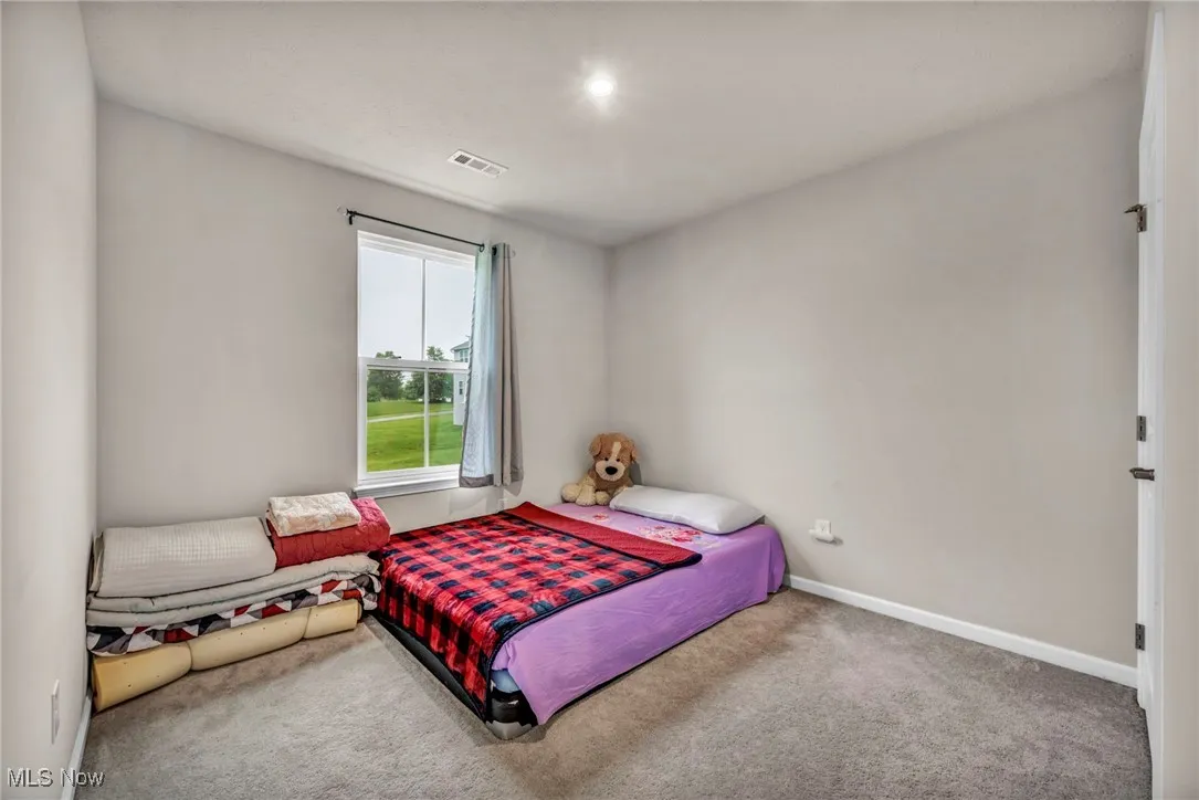 Bedroom featuring carpet flooring and baseboards