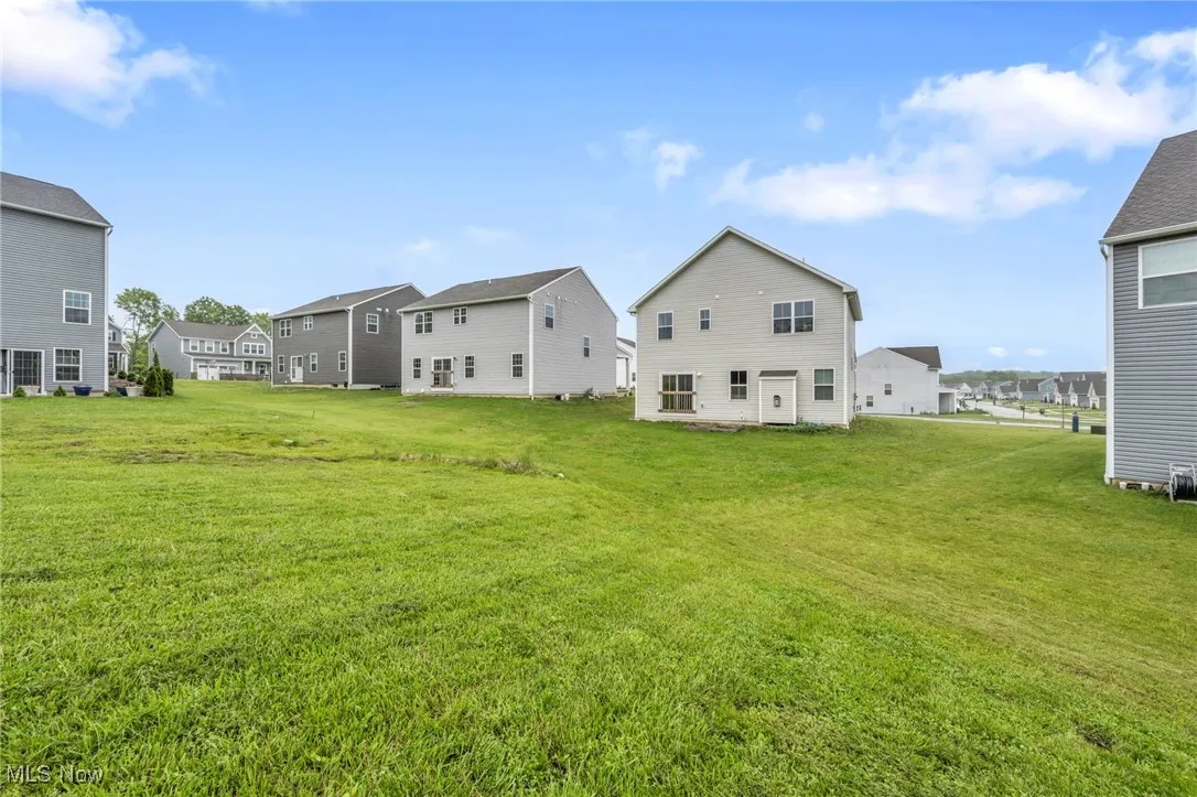 Back of house featuring a yard and a residential view