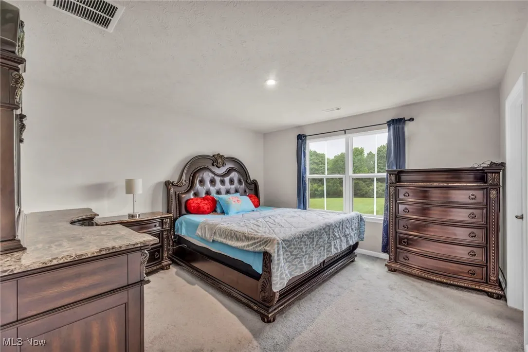 Bedroom with light carpet, recessed lighting, a textured ceiling, and baseboards