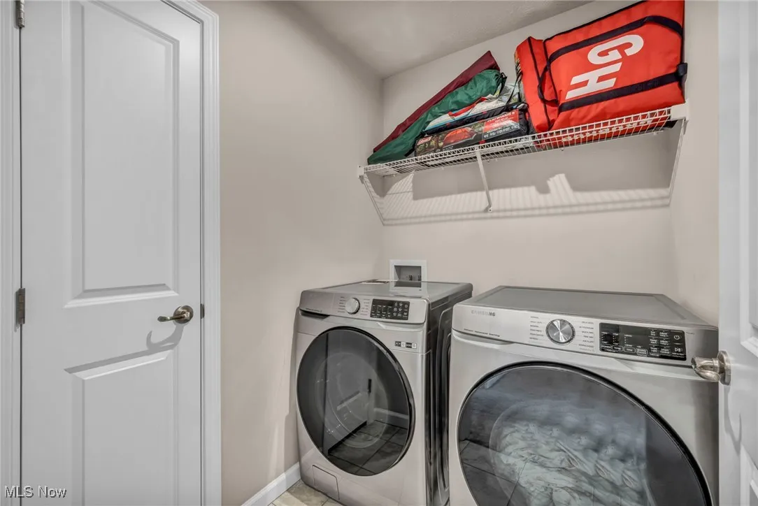 Washroom featuring washer and dryer and baseboards