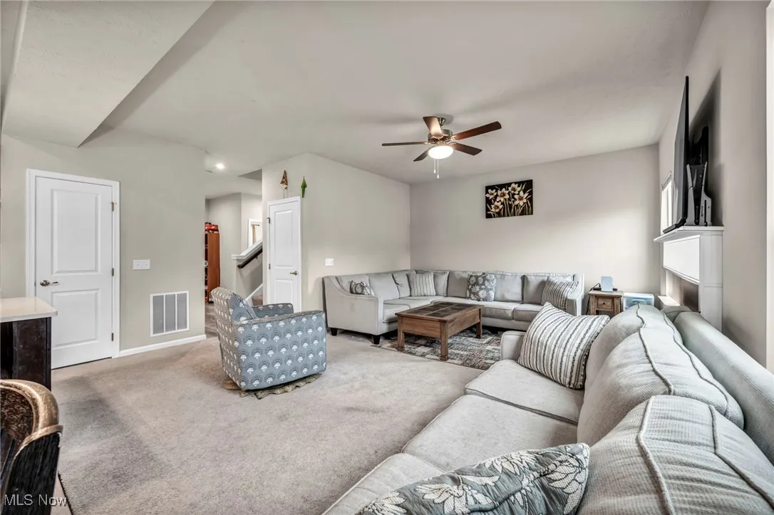 Living room featuring a ceiling fan, carpet floors, baseboards, and recessed lighting