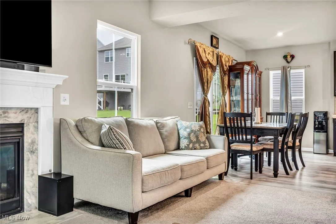 Living area with a high end fireplace and light wood-style flooring