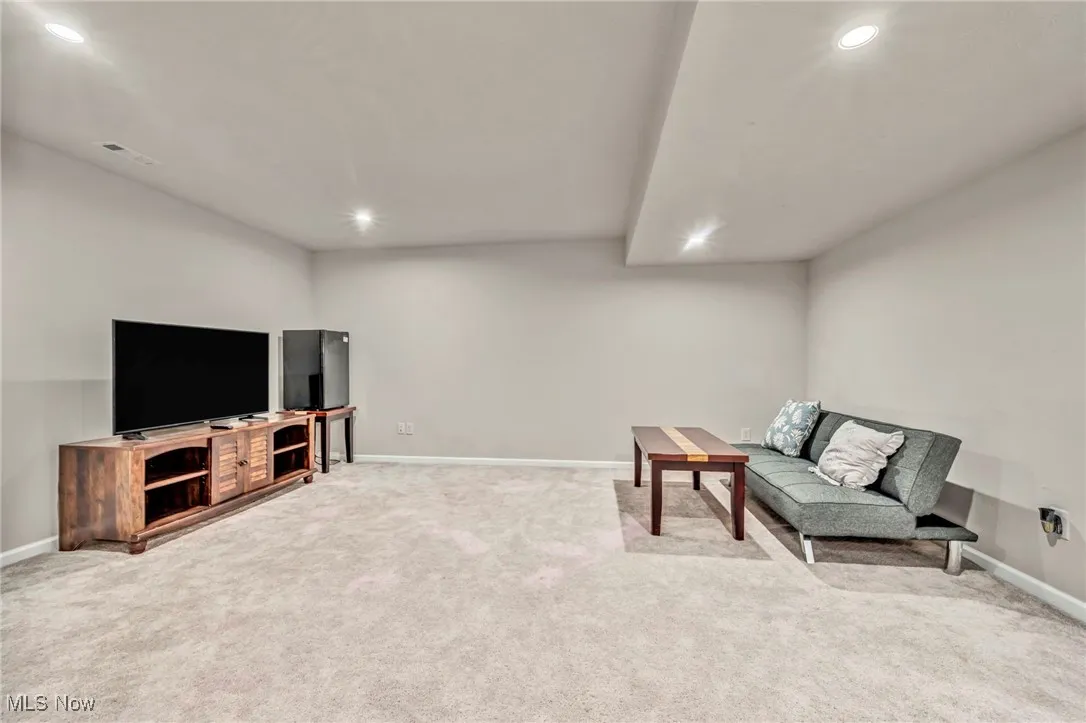 Living area with recessed lighting, baseboards, and carpet floors