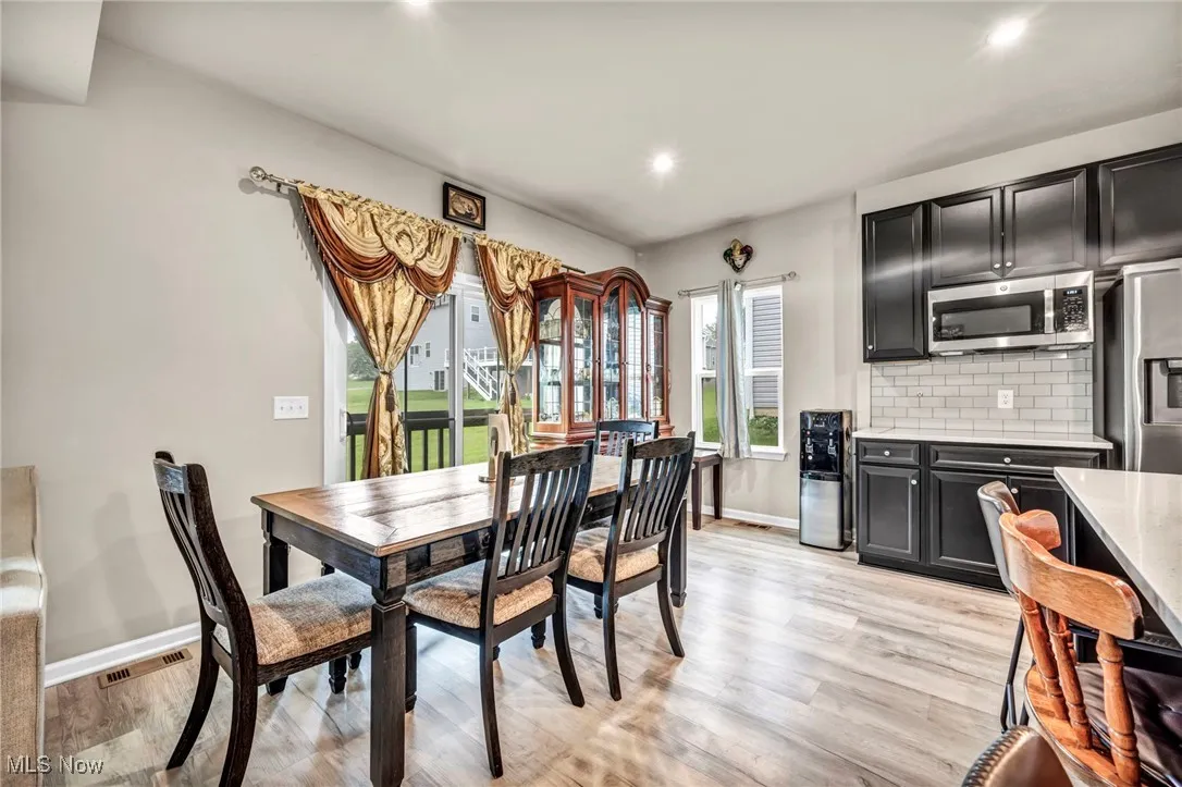 Dining room with healthy amount of natural light, recessed lighting, light wood-style flooring, and baseboards
