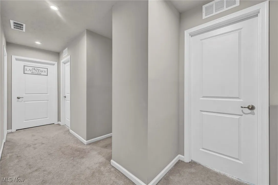 Hall with light carpet, baseboards, and recessed lighting