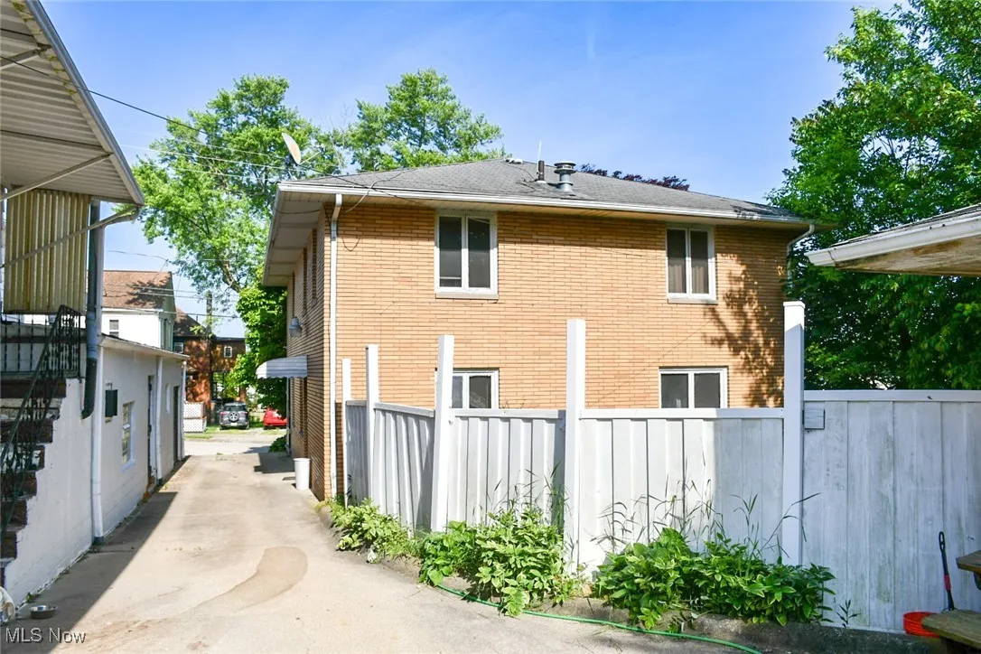 View of side of property with brick siding and a shingled roof
