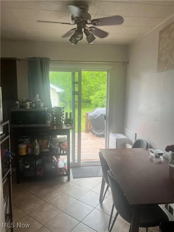 Dining room with light tile patterned flooring and ceiling fan