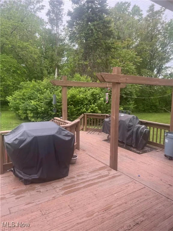 Deck featuring a grill and view of scattered trees