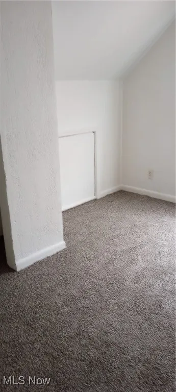 Carpeted empty room with baseboards