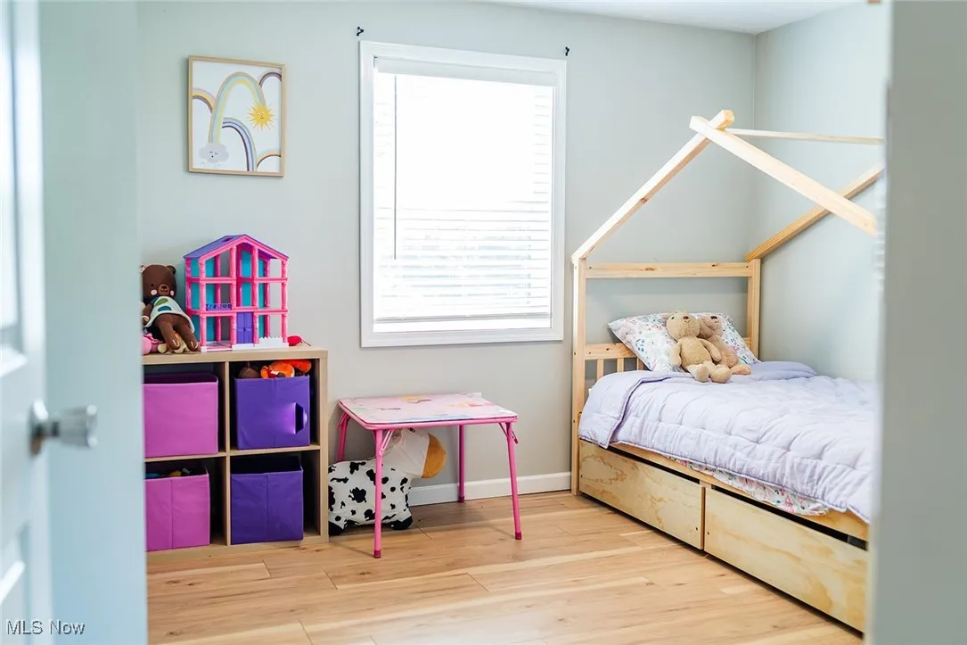 Bedroom featuring wood finished floors and baseboards