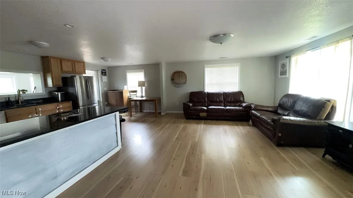 Living area featuring light wood-type flooring and baseboards