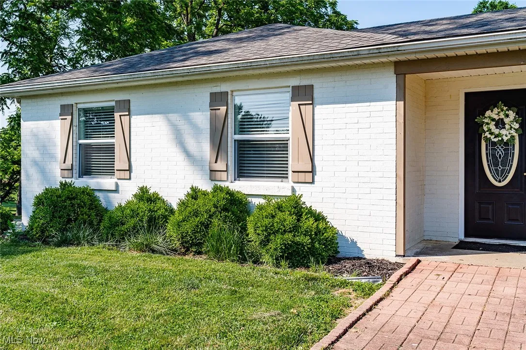 Property entrance with brick siding and roof with shingles