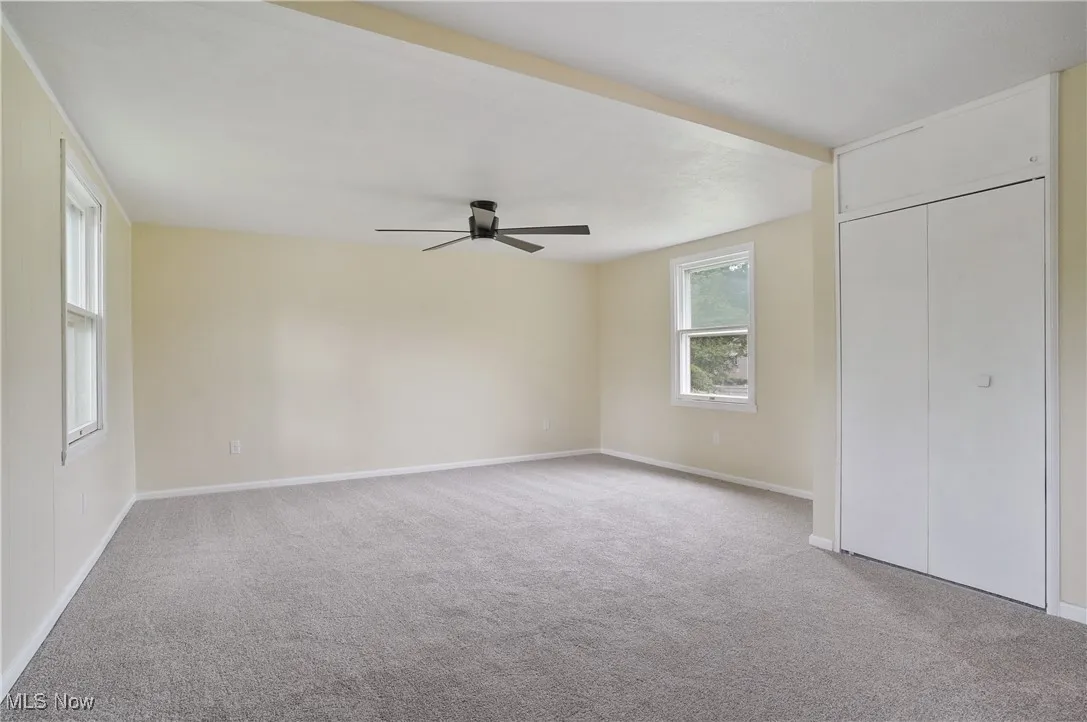 Unfurnished bedroom with carpet floors, baseboards, a ceiling fan, and a closet