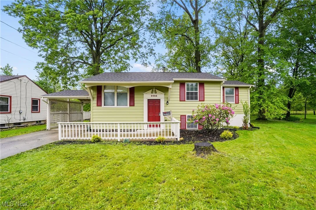 View of front facade featuring a front lawn, driveway, and covered porch