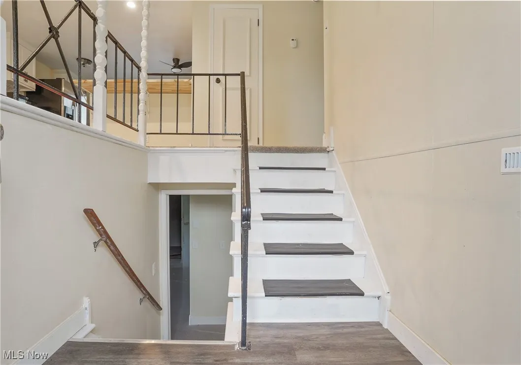Stairway featuring wood finished floors and baseboards