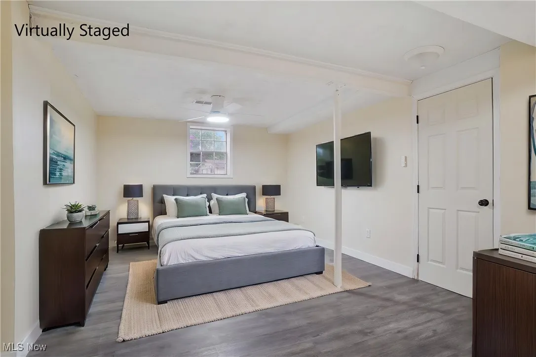 Bedroom with dark wood finished floors and baseboards