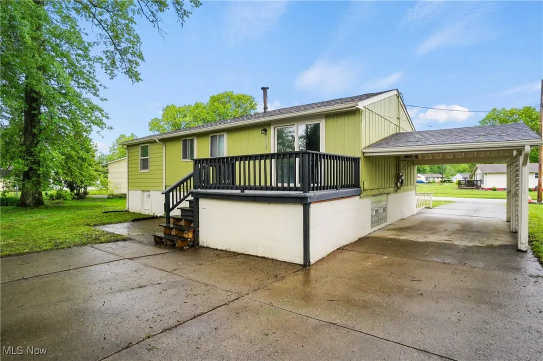View of front of house with driveway, a carport, and a front yard