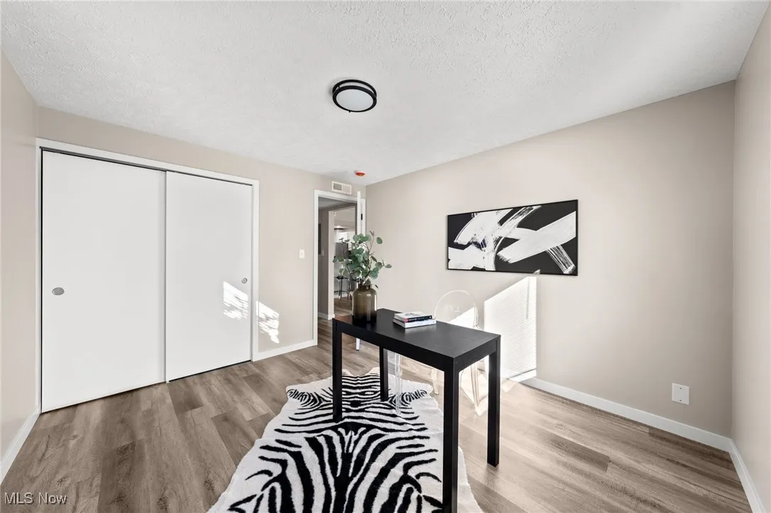 Office space featuring wood finished floors, a textured ceiling, and baseboards